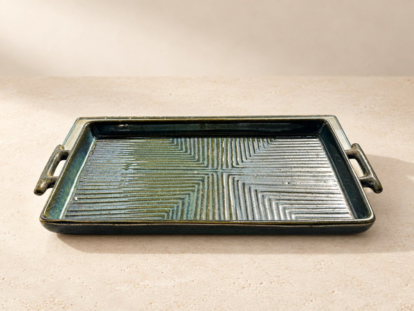 Longline charcoal ceramic serving tray on warm limestone
