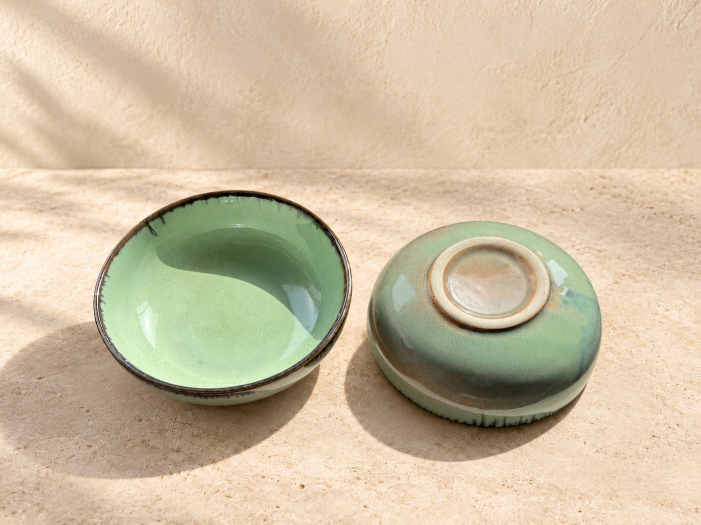 Sage-glazed ceramic bowl showing its rim and handmade finish