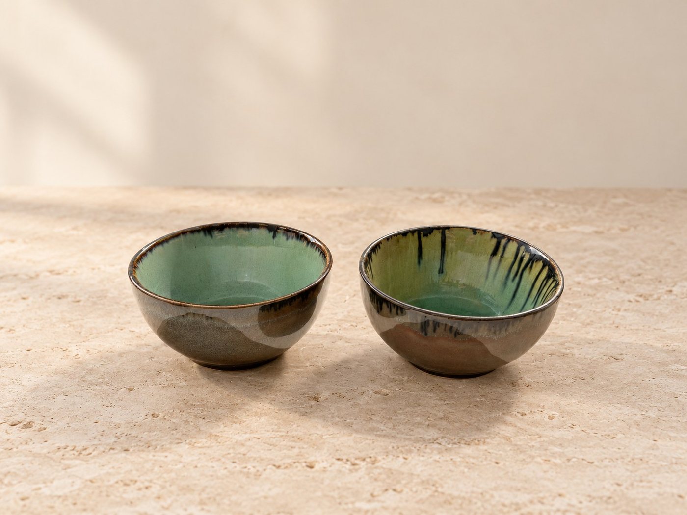 Two contrasting green and charcoal ceramic bowls